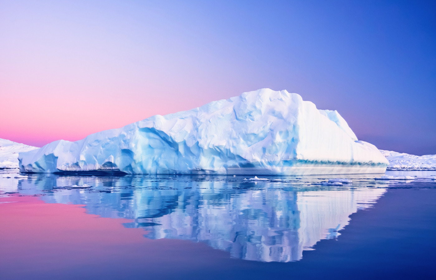 Iceberg glowing at sunset in calm Arctic waters
