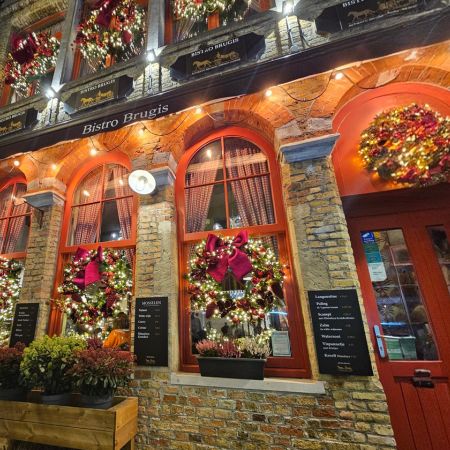 Bistro frontage in Bruges lit with festive wreaths