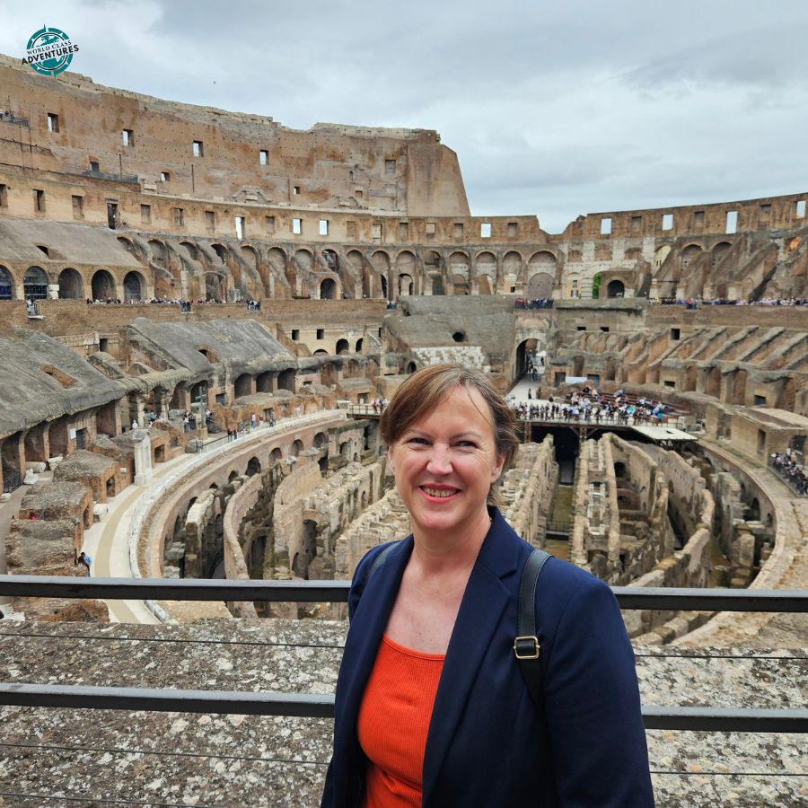 Bridget Perriman at the Colosseum in Rome, with the ancient interior seating and arena visible behind her